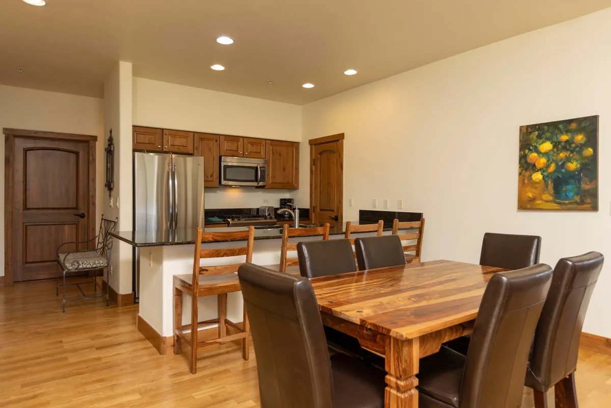 A cozy dining area adjacent to the kitchen, with a welcoming dining table, elegant cabinetry, and tasteful wall art. The space is designed for family meals, entertaining guests, and enjoying time together.
